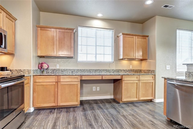 kitchen featuring dark hardwood / wood-style flooring, built in desk, a healthy amount of sunlight, and appliances with stainless steel finishes