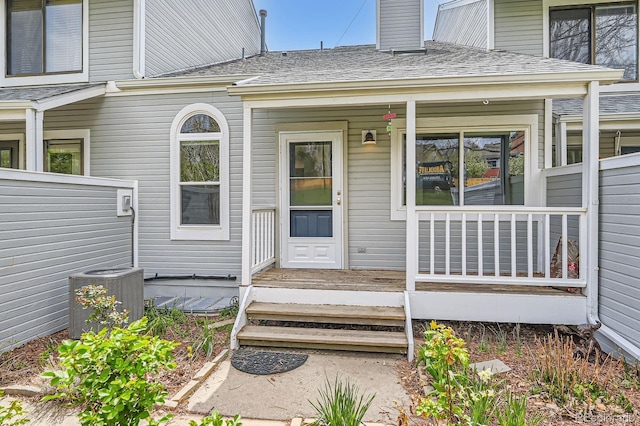 494 Owl Dr Unit 4, Louisville, CO 80027 - entrance to property featuring central AC, a porch, a shingled roof, and a chimney