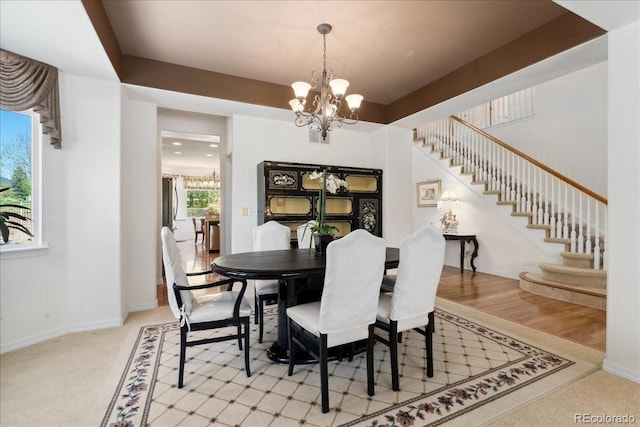 7132 S Tempe Ct, Aurora, CO 80016 - dining area featuring a chandelier, stairway, light colored carpet, and baseboards