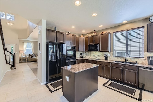 3490 Craftsbury Dr, Highlands Ranch, CO 80126 - kitchen with black appliances, dark brown cabinetry, a kitchen island, backsplash, and light stone counters