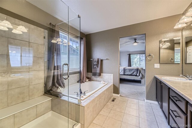 3490 Craftsbury Dr, Highlands Ranch, CO 80126 - ensuite bathroom featuring a textured wall, vanity, a stall shower, a garden tub, and healthy amount of natural light