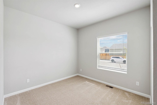 unfurnished room featuring light carpet