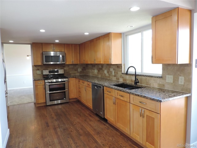 7753 W Plymouth Pl S, Littleton, CO 80128 - kitchen with appliances with stainless steel finishes, a sink, dark wood-style floors, decorative backsplash, and dark stone countertops