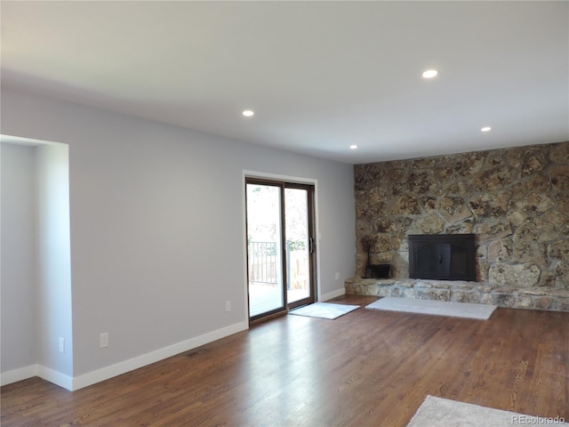 7753 W Plymouth Pl S, Littleton, CO 80128 - unfurnished living room with wood finished floors, baseboards, recessed lighting, and a stone fireplace
