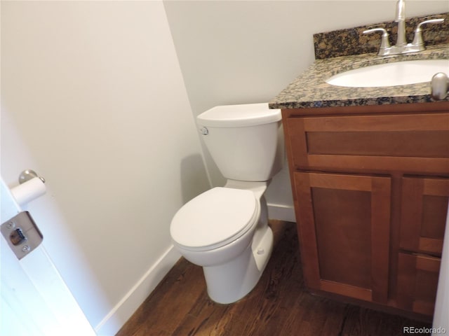 7753 W Plymouth Pl S, Littleton, CO 80128 - half bathroom with wood finished floors, vanity, baseboards, and toilet