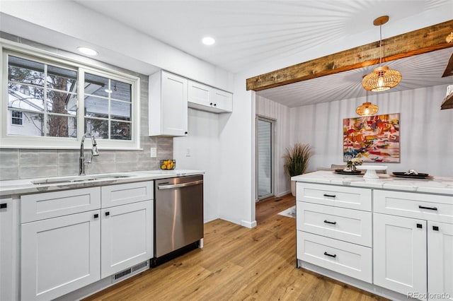 kitchen featuring pendant lighting, white cabinetry, dishwasher, sink, and light wood-type flooring