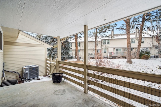 snow covered patio with cooling unit