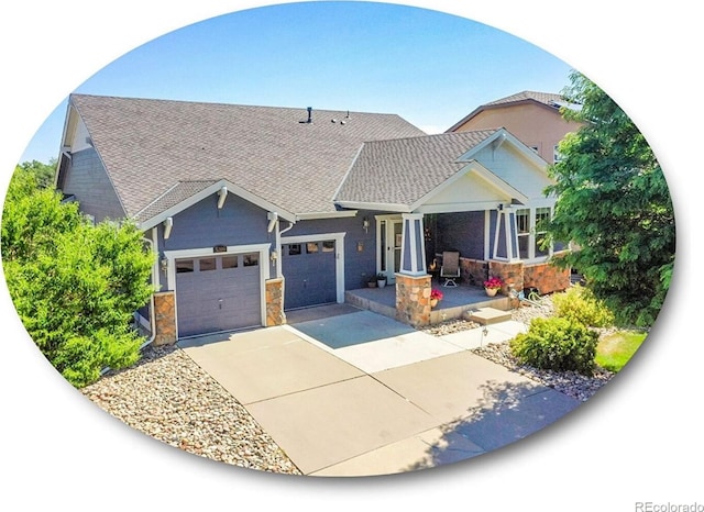 5309 W Hoover Dr, Littleton, CO 80123 - view of front of property featuring concrete driveway, stone siding, a garage, and roof with shingles