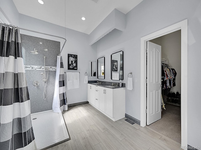 5309 W Hoover Dr, Littleton, CO 80123 - bathroom featuring a shower with curtain, double vanity, wood finished floors, a spacious closet, and recessed lighting