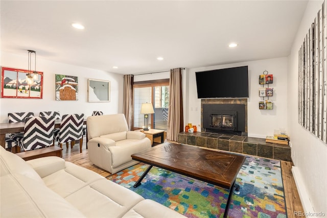 living area featuring recessed lighting, baseboards, wood finished floors, and a tiled fireplace