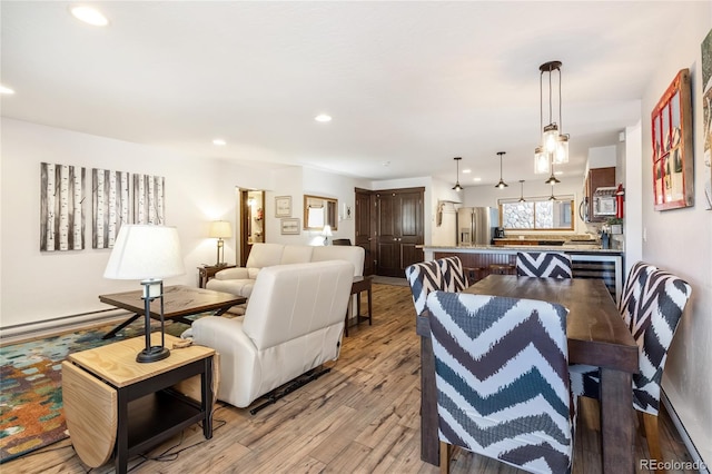 living room with baseboard heating, light wood-style flooring, recessed lighting, and wine cooler