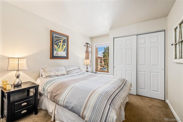 carpeted bedroom featuring a closet and baseboards