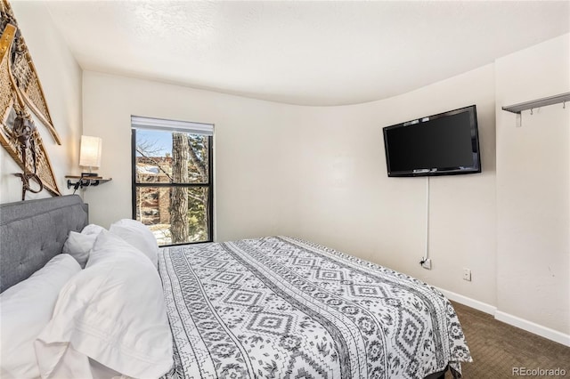 bedroom featuring baseboards and dark colored carpet