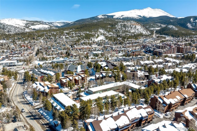 snowy aerial view featuring a residential view and a mountain view