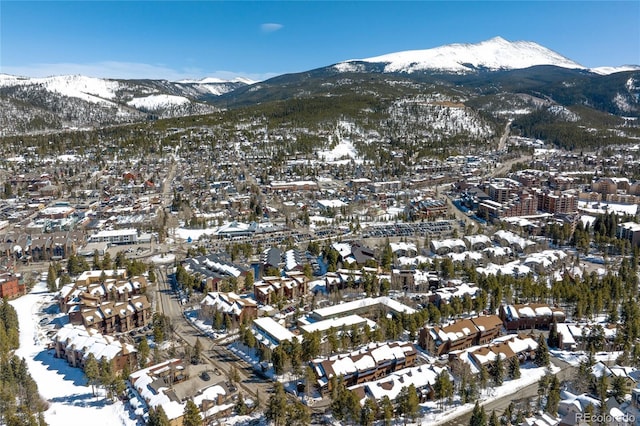 snowy aerial view featuring a mountain view and a residential view