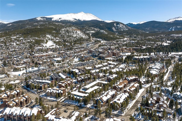 snowy aerial view featuring a mountain view and a residential view