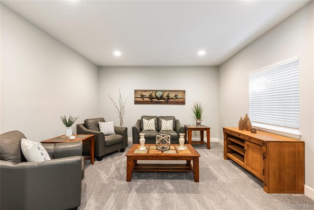 living room featuring light carpet, baseboards, and recessed lighting