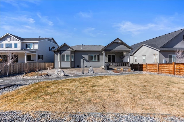 view of front of home featuring a fenced backyard, a patio, and a front lawn