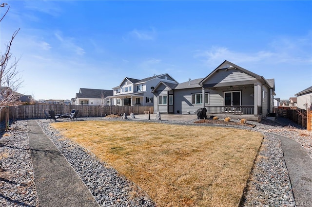 view of front of house with a patio area, a fenced backyard, and a front yard