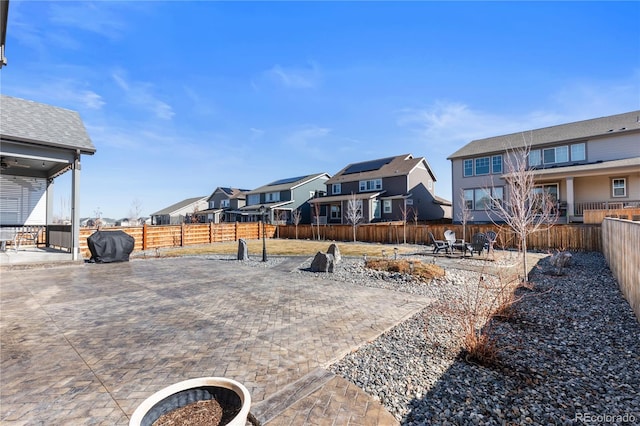 view of yard with a patio, a fenced backyard, and a residential view