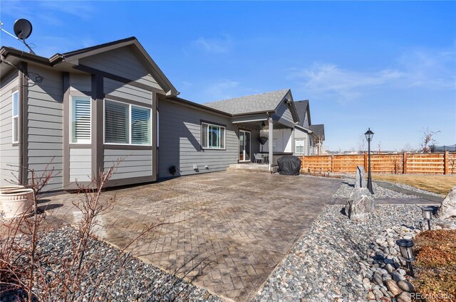 view of home's exterior with a patio area and fence