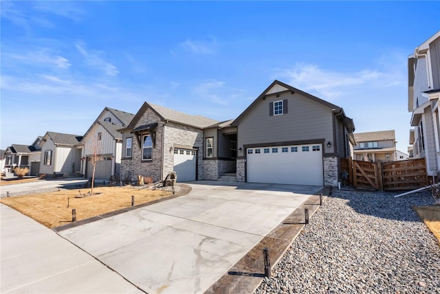 view of front of house with driveway, a garage, fence, and a residential view