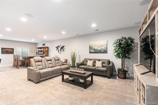 living room featuring recessed lighting, light colored carpet, and baseboards