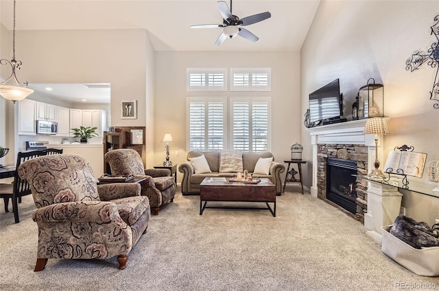 601 Clarendon Loop, Castle Pines, CO 80108 - living room with light carpet, ceiling fan, a fireplace, and a towering ceiling