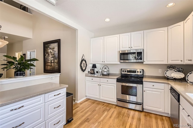 601 Clarendon Loop, Castle Pines, CO 80108 - kitchen with appliances with stainless steel finishes, recessed lighting, light wood-style floors, white cabinets, and light countertops