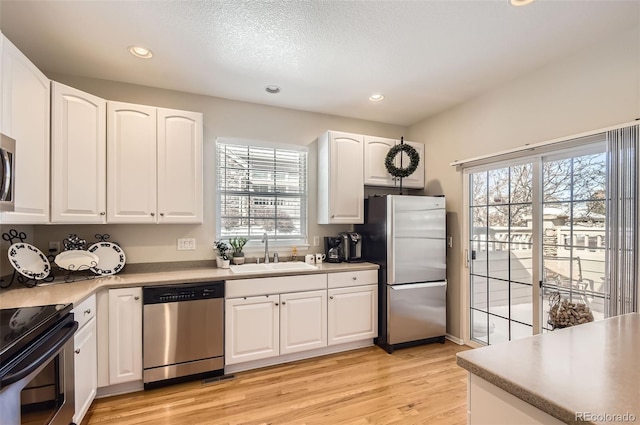601 Clarendon Loop, Castle Pines, CO 80108 - kitchen with stainless steel appliances, plenty of natural light, light wood-style floors, recessed lighting, and white cabinetry