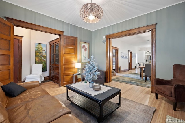 1554 N Pennsylvania St, Denver, CO 80203 - living room featuring baseboards, light wood finished floors, and a notable chandelier