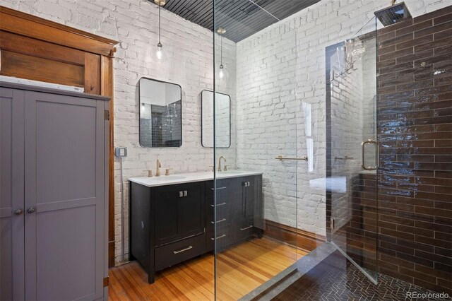 1554 N Pennsylvania St, Denver, CO 80203 - full bath featuring a stall shower, double vanity, a sink, and wood finished floors