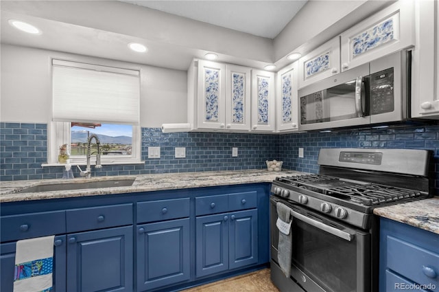235 Blazing Saddle Trl, Cotopaxi, CO 81223 - kitchen featuring stainless steel appliances, blue cabinetry, a sink, backsplash, and light stone counters