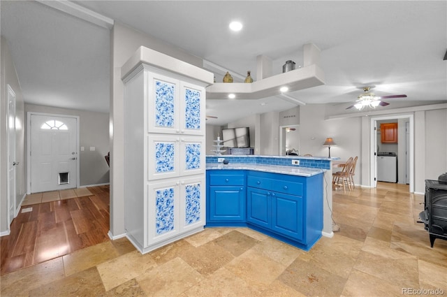 235 Blazing Saddle Trl, Cotopaxi, CO 81223 - kitchen featuring blue cabinets, washer / clothes dryer, ceiling fan, baseboards, and a peninsula