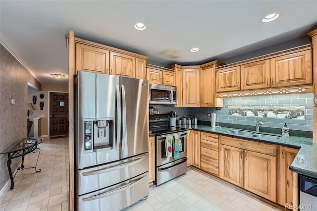 kitchen with backsplash, stainless steel appliances, dark stone countertops, and sink