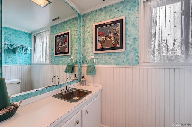 bathroom with vanity, toilet, and crown molding