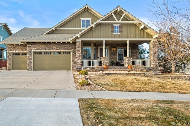 craftsman inspired home featuring a garage, a front yard, and covered porch