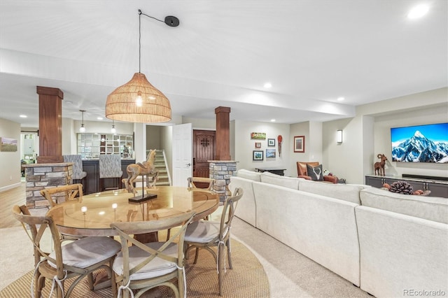 carpeted dining space with decorative columns