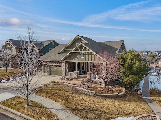 craftsman inspired home featuring a porch, a garage, and a front yard