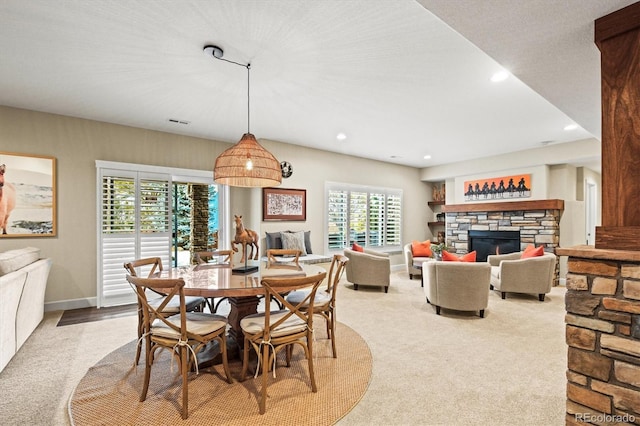 carpeted dining room featuring a fireplace