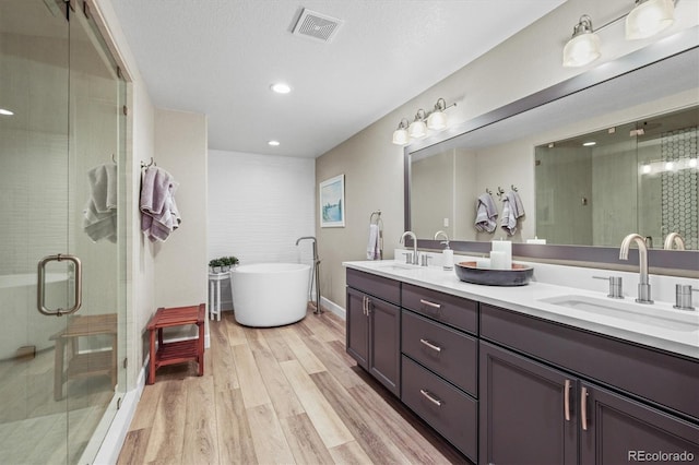 bathroom with vanity, hardwood / wood-style floors, and shower with separate bathtub