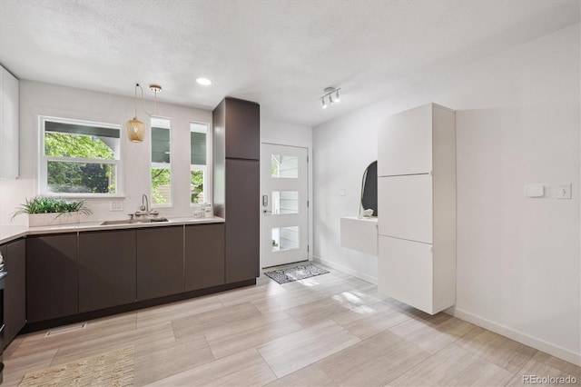 2059 S Balsam St, Lakewood, CO 80227 - kitchen with a sink, light countertops, modern cabinets, a textured ceiling, and pendant lighting