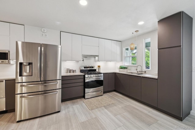 2059 S Balsam St, Lakewood, CO 80227 - kitchen with appliances with stainless steel finishes, a sink, modern cabinets, light countertops, and recessed lighting