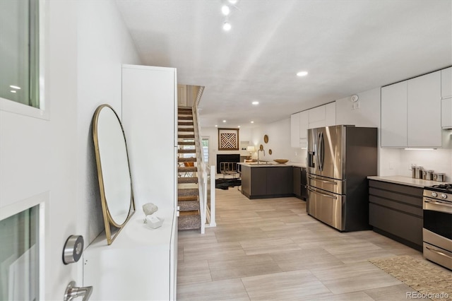 2059 S Balsam St, Lakewood, CO 80227 - kitchen featuring stainless steel appliances, light countertops, white cabinetry, modern cabinets, and a peninsula