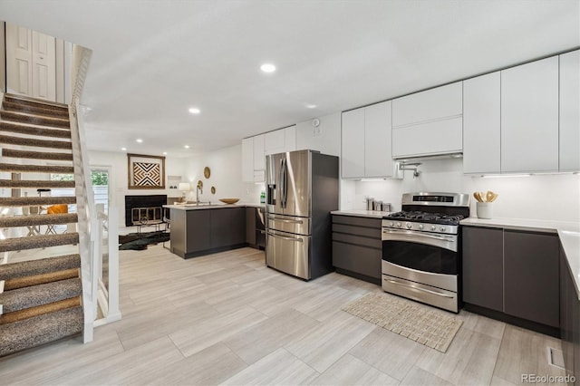 2059 S Balsam St, Lakewood, CO 80227 - kitchen with appliances with stainless steel finishes, modern cabinets, a peninsula, light countertops, and recessed lighting