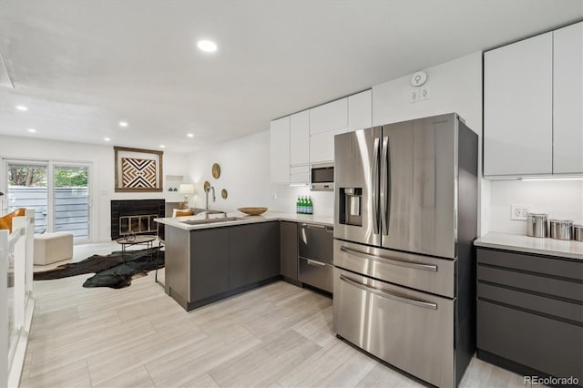 2059 S Balsam St, Lakewood, CO 80227 - kitchen with appliances with stainless steel finishes, a peninsula, a sink, light countertops, and recessed lighting