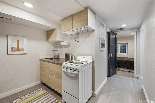 2059 S Balsam St, Lakewood, CO 80227 - kitchen with electric stove, a sink, light tile patterned floors, a textured wall, and baseboards