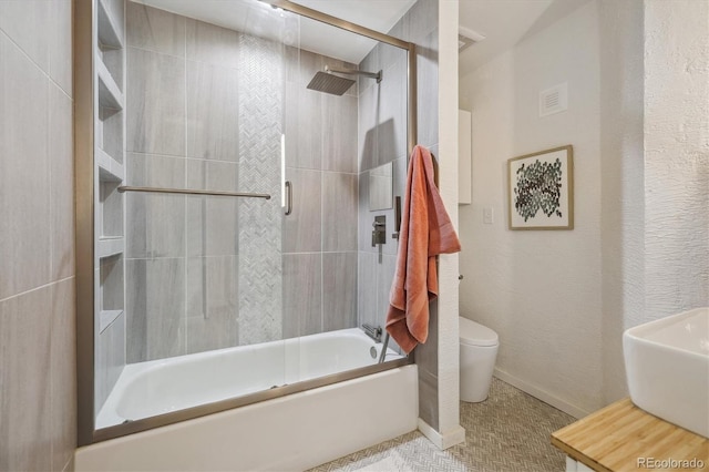 2059 S Balsam St, Lakewood, CO 80227 - bathroom featuring toilet, combined bath / shower with glass door, and a sink