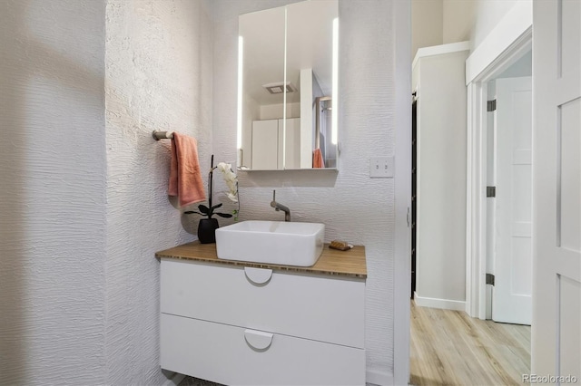 2059 S Balsam St, Lakewood, CO 80227 - bathroom with vanity, wood finished floors, and a textured wall