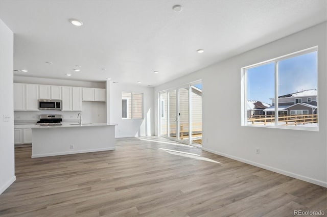 unfurnished living room featuring light hardwood / wood-style flooring and sink